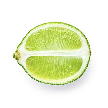 Eine frisch halbierte Limette auf weissem Hintergrund.